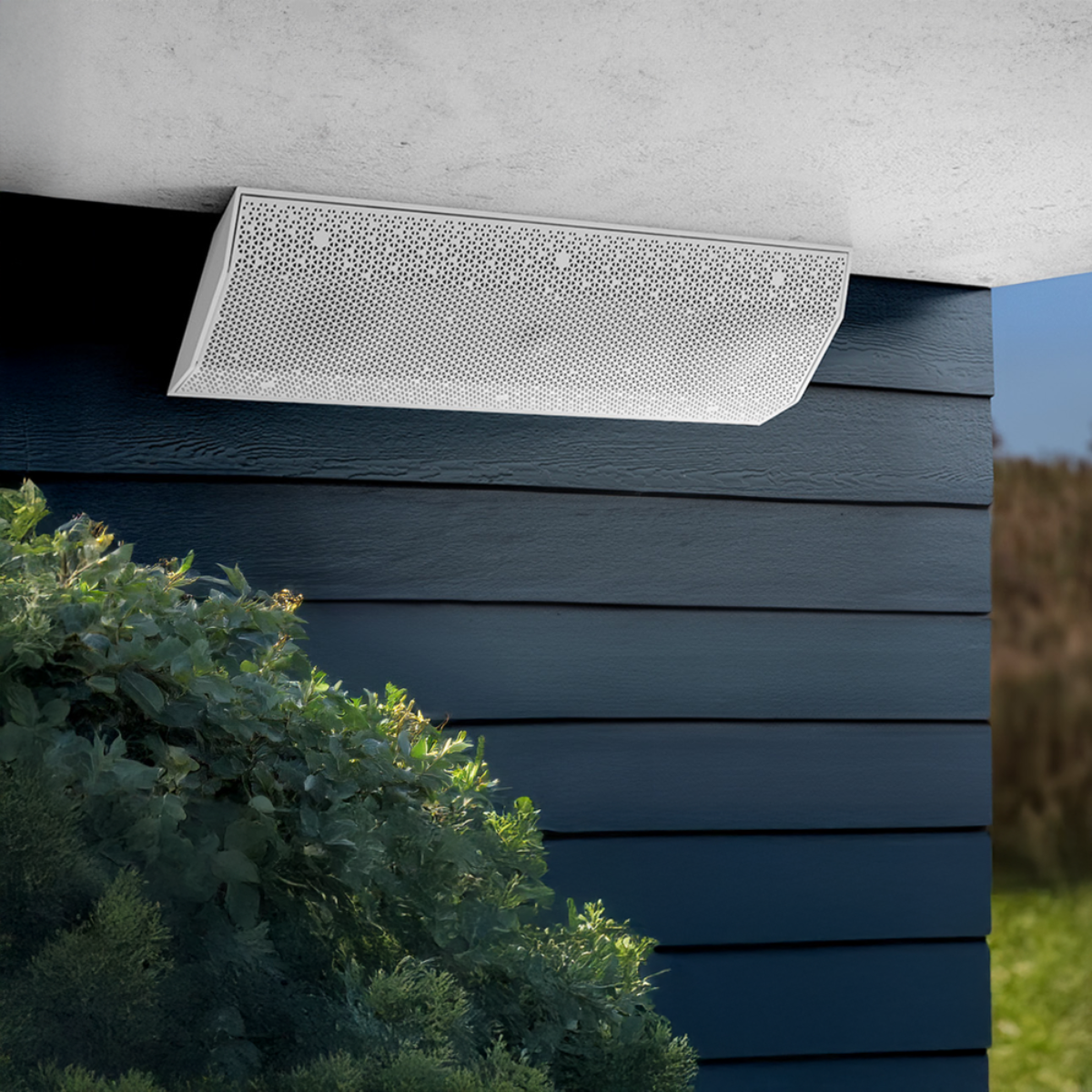 Ventilation grille on a building exterior with greenery in the foreground