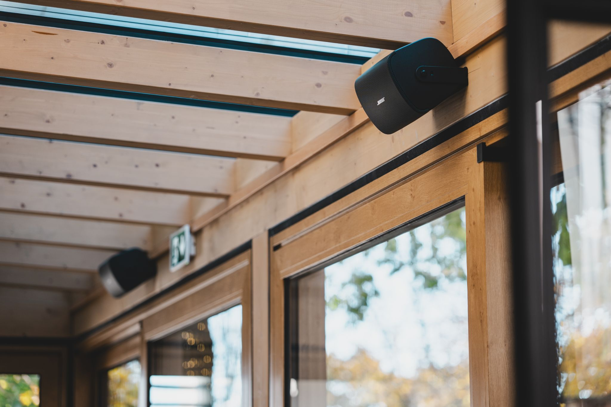 Wooden interior with ceiling lights and a window and Bose Speaker.