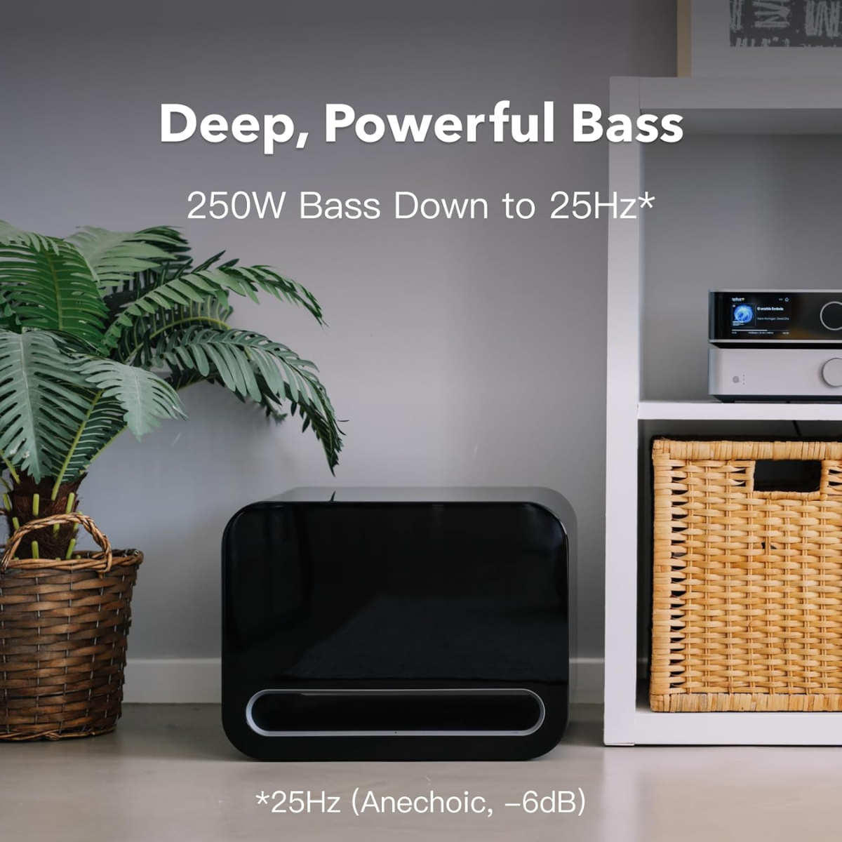 Black speaker on a floor with text about deep, powerful bass in a room setting.