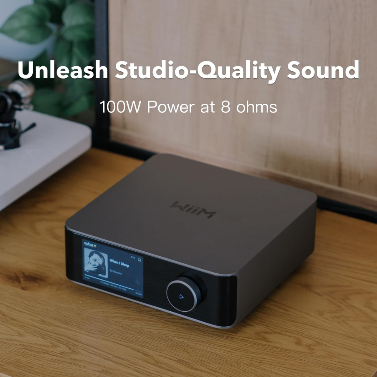 Audio amplifier on a wooden surface with text about studio-quality sound and power specifications.