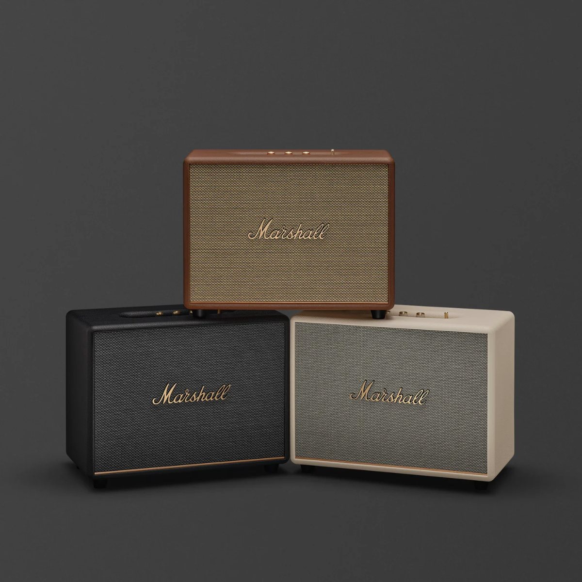 Three Marshall speakers of different colors on a dark background