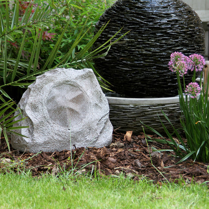 Decorative stone with a garden setting including plants and a woven basket.