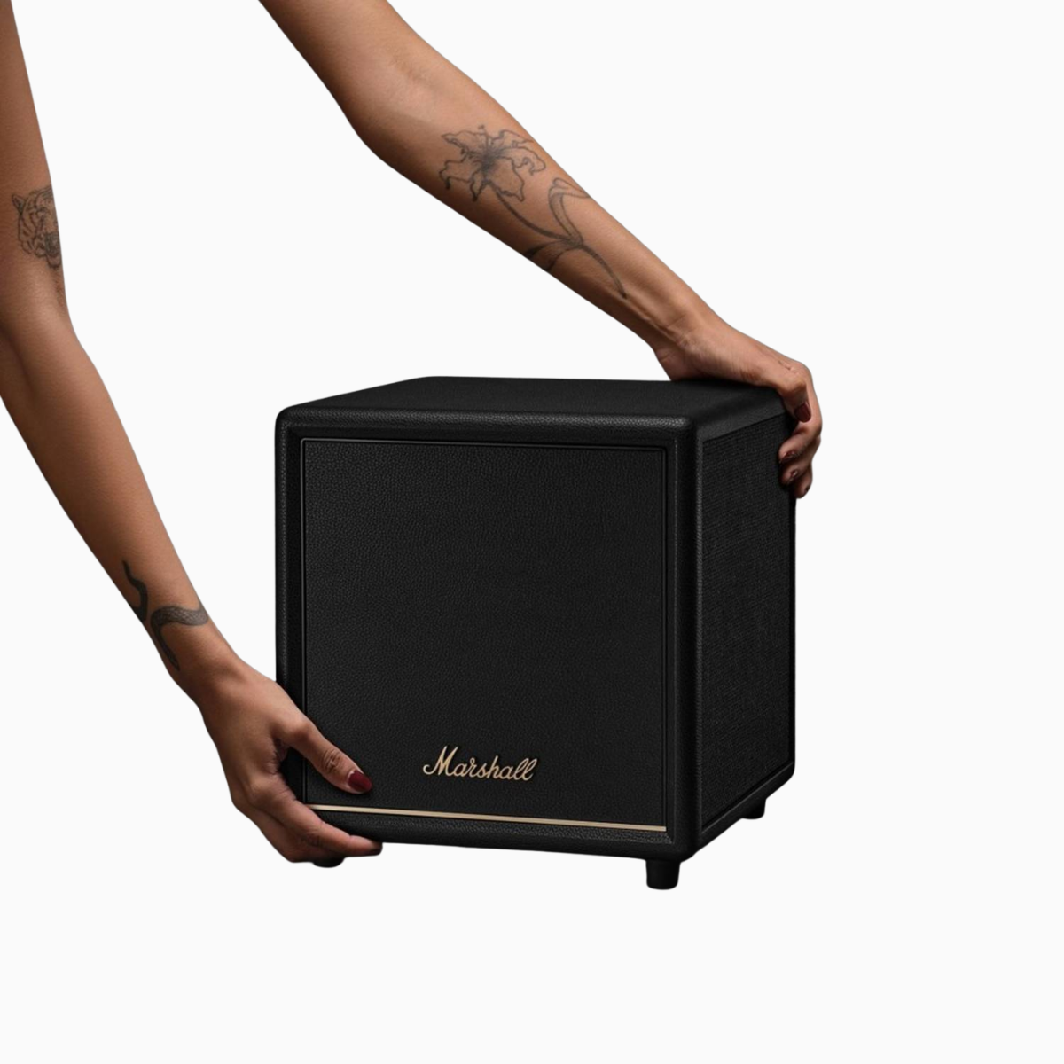 Person holding a Marshall speaker on a white background