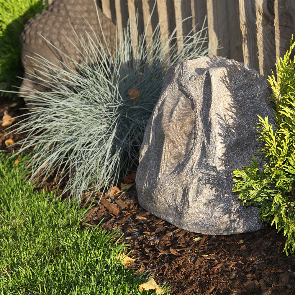 Decorative stone with grass and plants in a garden setting