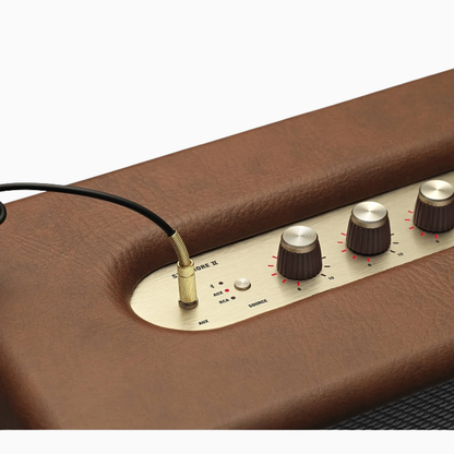 Brown amplifier with control panel and cable on a white background